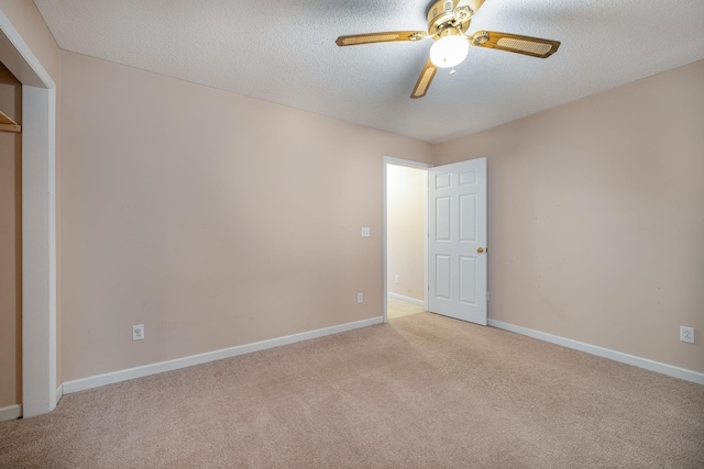 unfurnished bedroom with ceiling fan, light carpet, and a textured ceiling