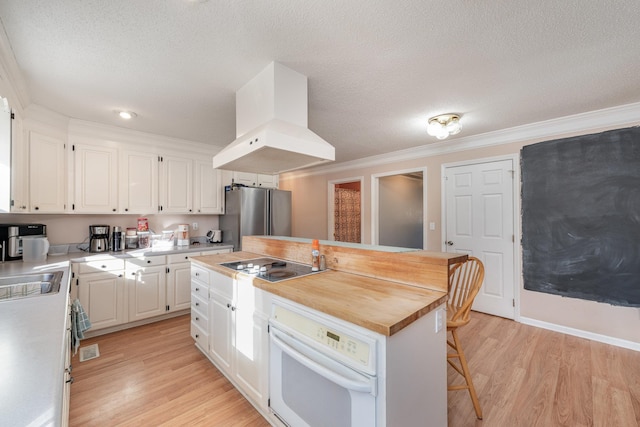 kitchen featuring a kitchen island, white cabinets, white oven, stainless steel refrigerator, and extractor fan