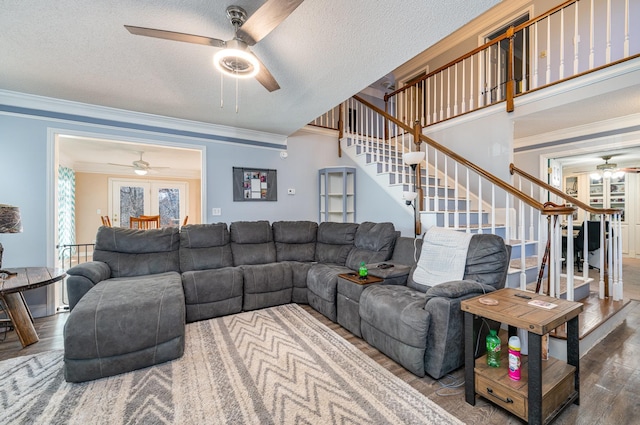 living room featuring a textured ceiling, french doors, crown molding, and wood-type flooring