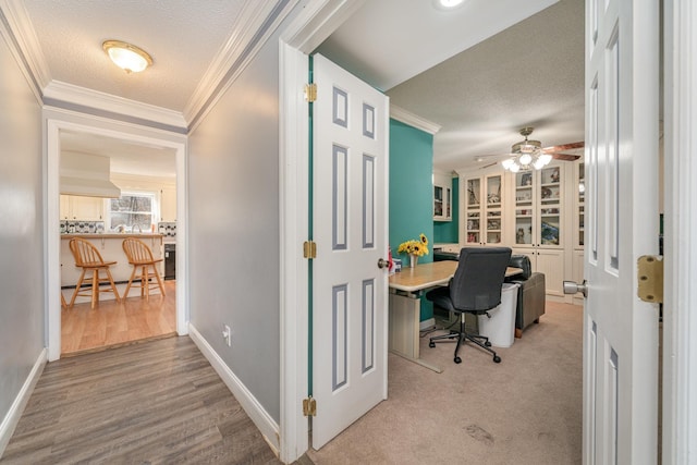 office space with ornamental molding, ceiling fan, light wood-type flooring, and a textured ceiling