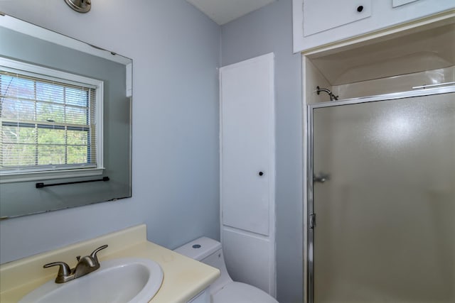 bathroom with toilet, a shower with door, and vanity