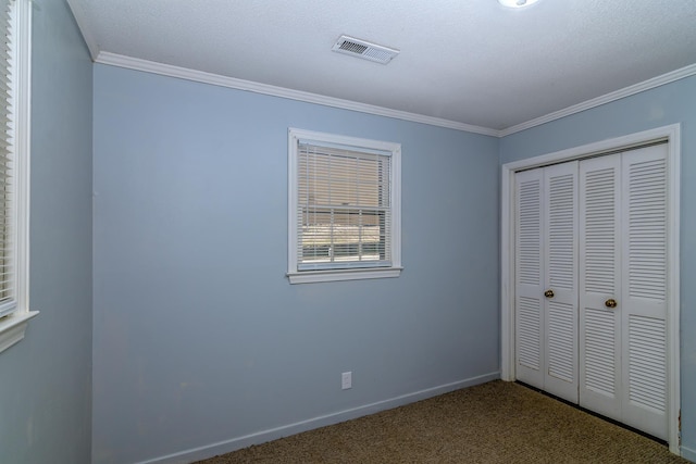 unfurnished bedroom with ornamental molding, a closet, and carpet