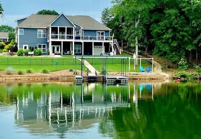 exterior space featuring a deck with water view and a lawn