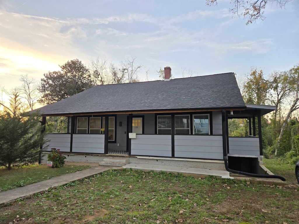 view of front of house featuring covered porch and a lawn