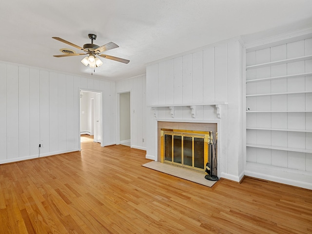 unfurnished living room with ceiling fan, light hardwood / wood-style floors, and built in features