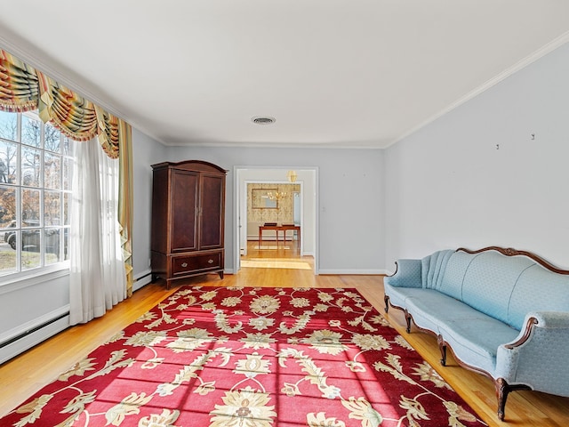 living area with hardwood / wood-style floors, plenty of natural light, and a baseboard heating unit