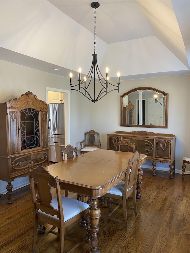 dining space with a notable chandelier, vaulted ceiling, and dark hardwood / wood-style floors