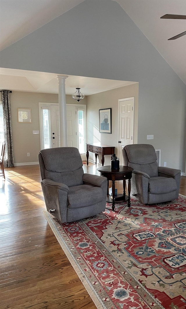 living room with ceiling fan, vaulted ceiling, wood-type flooring, and ornate columns