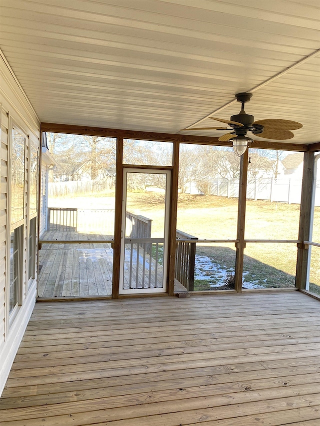 unfurnished sunroom featuring ceiling fan and a wealth of natural light