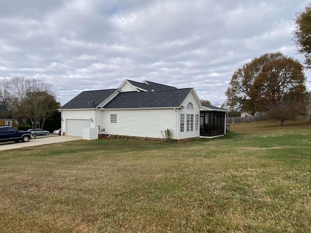 view of side of property featuring a garage, a yard, and a sunroom