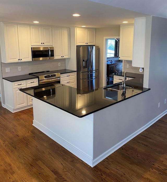 kitchen featuring sink, white cabinetry, kitchen peninsula, and appliances with stainless steel finishes