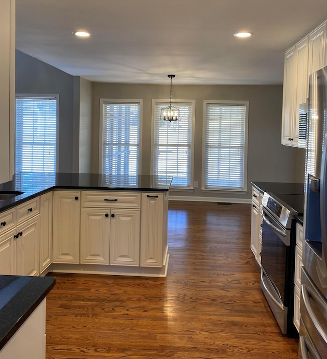 kitchen with stainless steel appliances, pendant lighting, dark hardwood / wood-style floors, white cabinetry, and an inviting chandelier