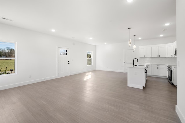 unfurnished living room with sink and hardwood / wood-style floors