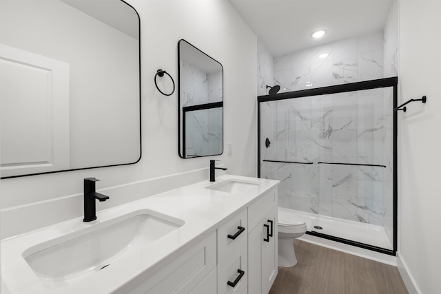 bathroom featuring vanity, toilet, a shower with shower door, and hardwood / wood-style flooring