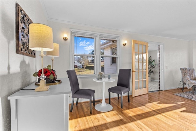 dining area with french doors, crown molding, and hardwood / wood-style flooring