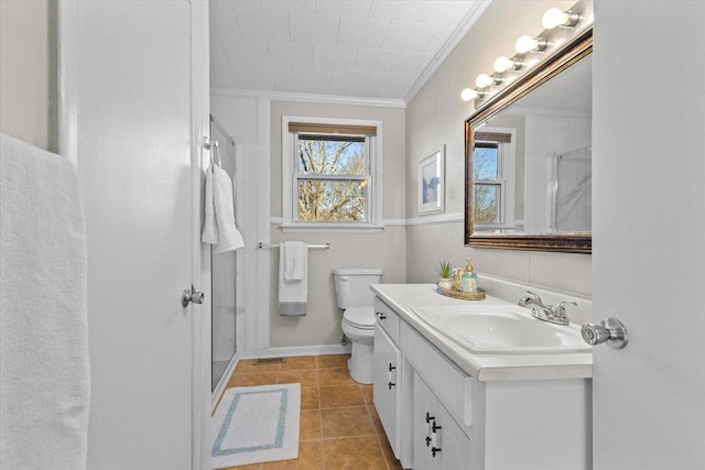 bathroom with toilet, tile patterned floors, a shower with door, vanity, and crown molding