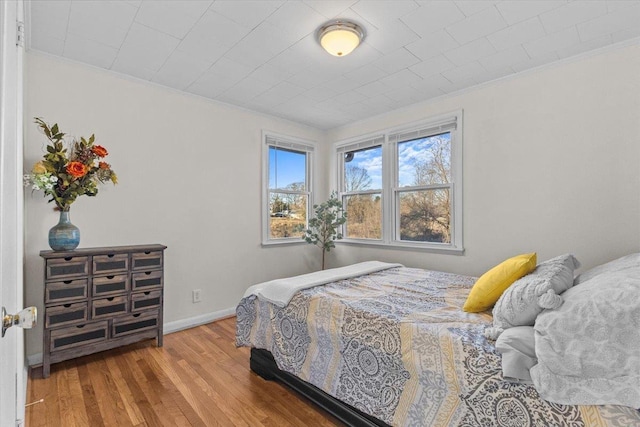 bedroom featuring hardwood / wood-style floors and crown molding