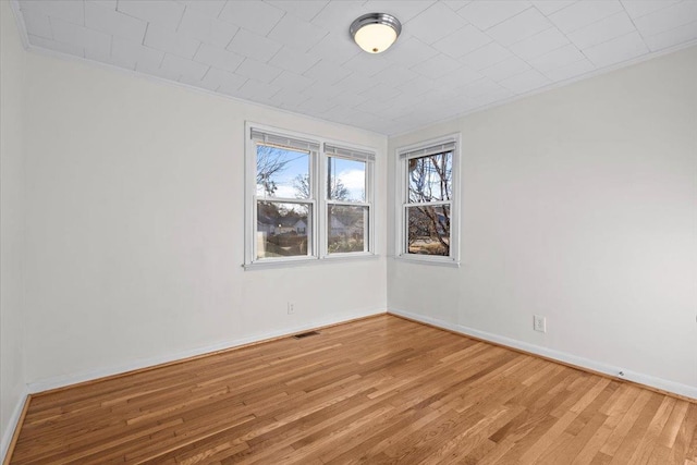 spare room featuring ornamental molding and hardwood / wood-style flooring