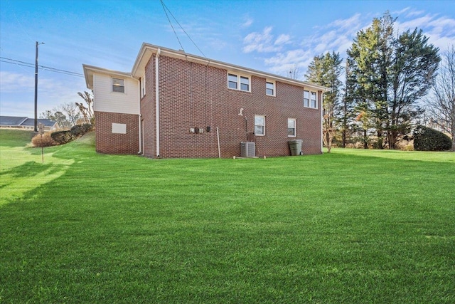 back of property featuring central air condition unit and a lawn