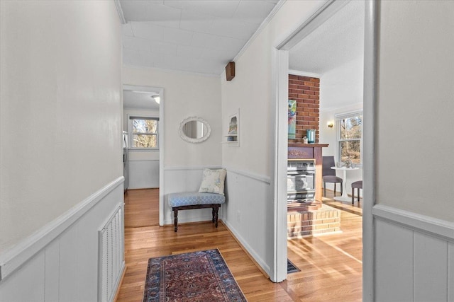 hallway featuring ornamental molding and light wood-type flooring