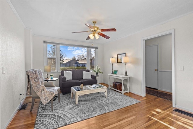 living room featuring ceiling fan, ornamental molding, and hardwood / wood-style floors