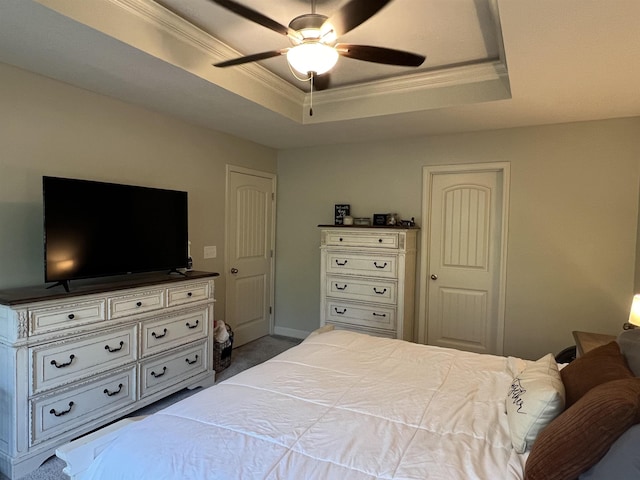 bedroom featuring ceiling fan, a tray ceiling, and ornamental molding