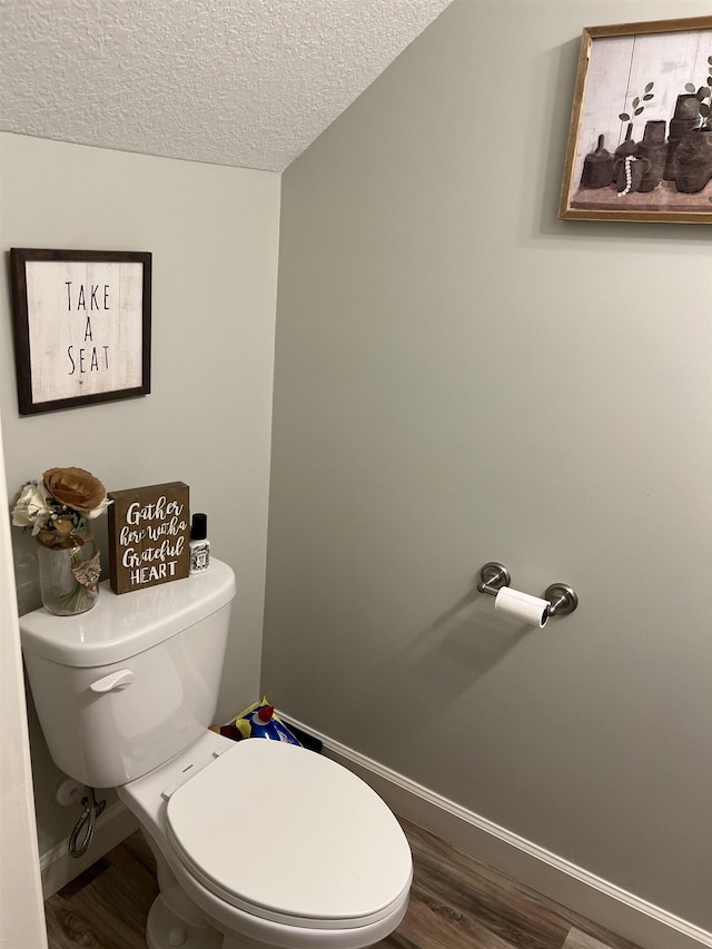 bathroom featuring toilet, a textured ceiling, and hardwood / wood-style flooring