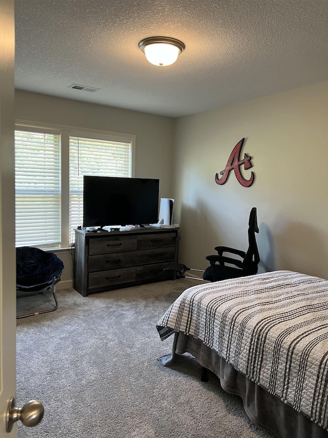 carpeted bedroom featuring a textured ceiling