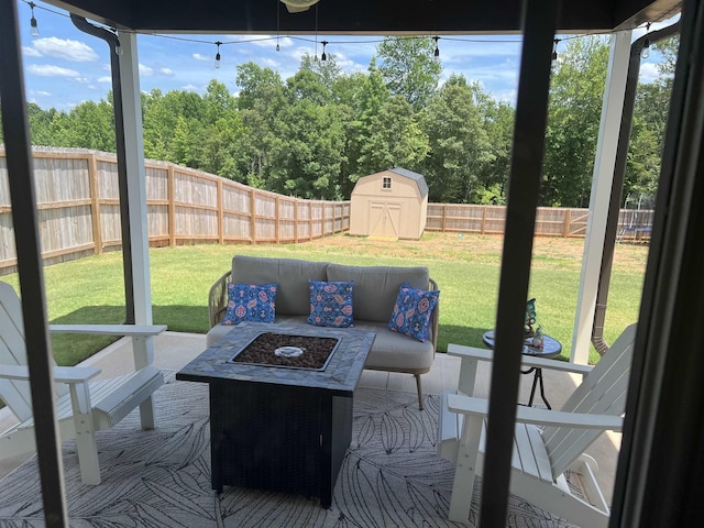 view of patio with an outdoor fire pit and a shed