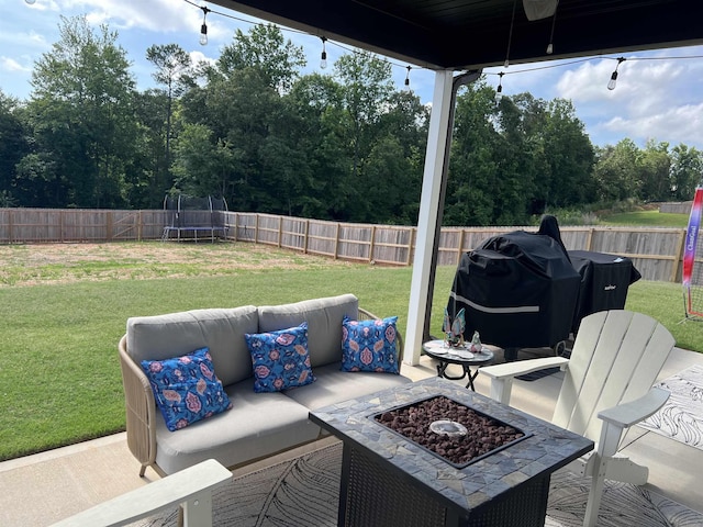 view of patio / terrace featuring a trampoline, a grill, and a fire pit