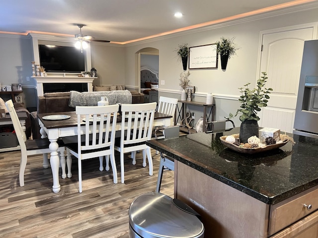 dining space with ceiling fan, ornamental molding, and wood-type flooring