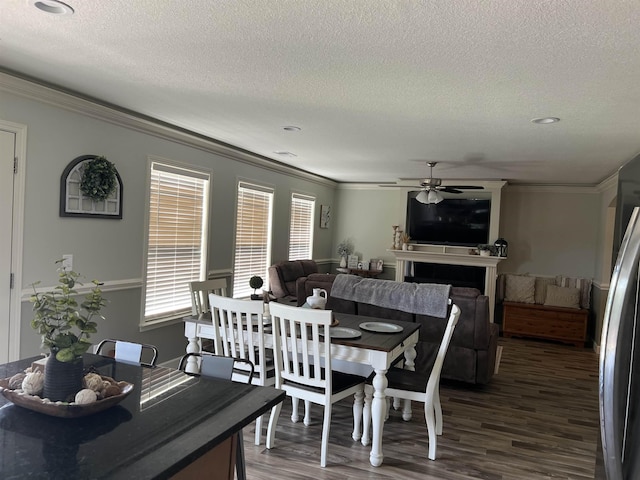 dining room with ceiling fan, crown molding, and dark hardwood / wood-style floors