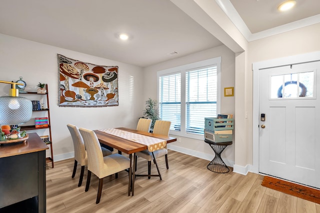 dining room featuring light hardwood / wood-style floors and crown molding