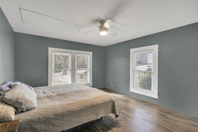 bedroom with ceiling fan, wood-type flooring, and multiple windows