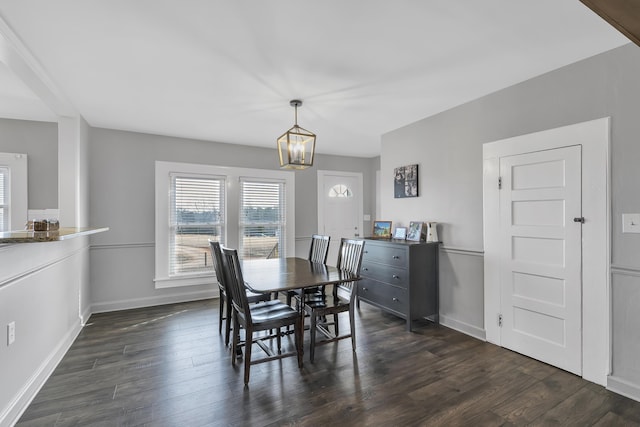 dining space featuring a notable chandelier and dark hardwood / wood-style flooring