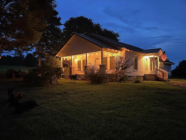 property exterior at dusk featuring a lawn