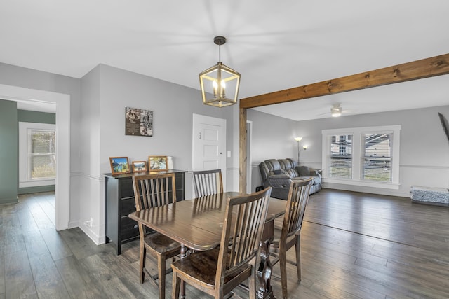 dining room with ceiling fan with notable chandelier, beam ceiling, and dark wood-type flooring