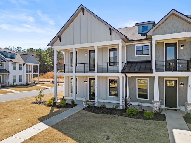 view of front of house featuring a front yard and a balcony