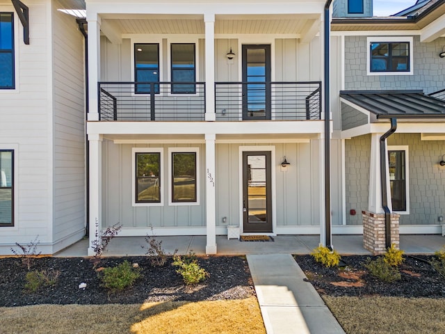 entrance to property featuring covered porch and a balcony