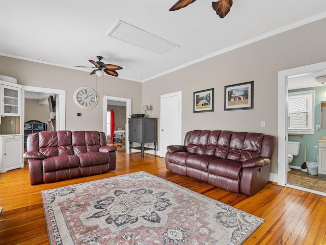 living room featuring ceiling fan, ornamental molding, and wood-type flooring