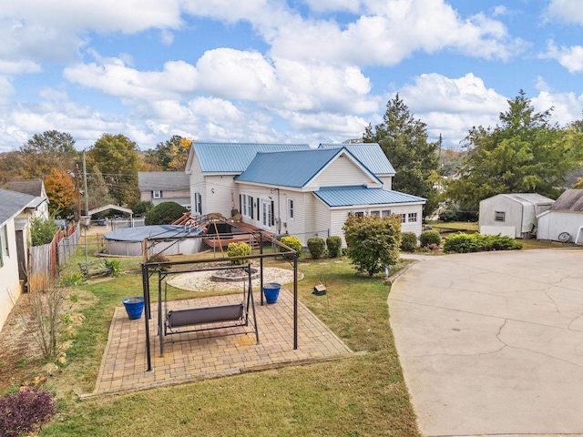 view of front of house featuring a gazebo, a patio area, a front lawn, and a shed