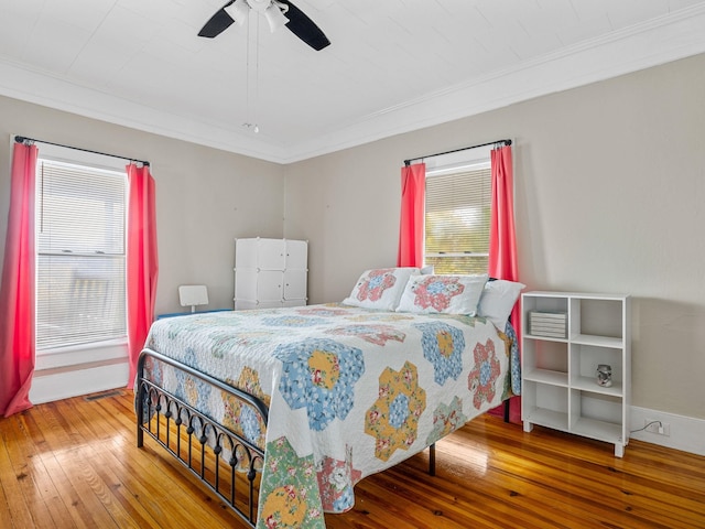 bedroom featuring ceiling fan, multiple windows, and hardwood / wood-style flooring