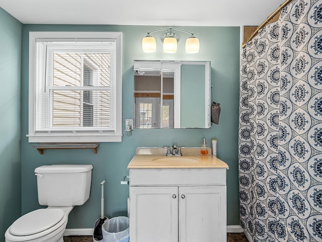 bathroom with curtained shower, a wealth of natural light, vanity, and toilet