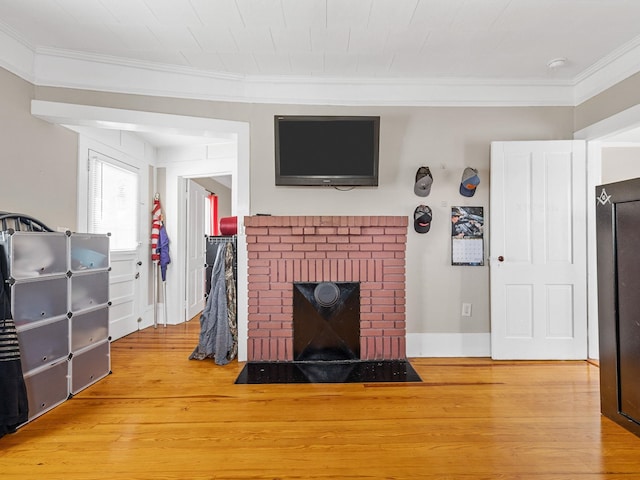 living room featuring a fireplace, hardwood / wood-style floors, and crown molding