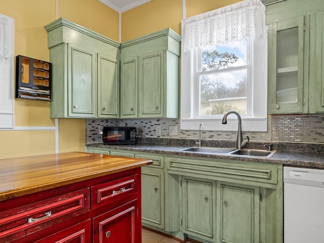 kitchen with dishwasher, backsplash, crown molding, sink, and light tile patterned flooring