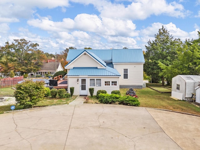 view of front of property with a front lawn and a shed