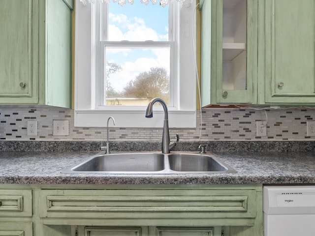 kitchen with white dishwasher, sink, decorative backsplash, and green cabinets