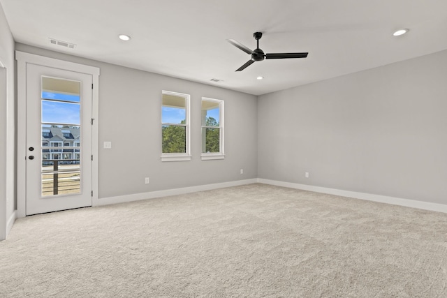 carpeted spare room featuring ceiling fan