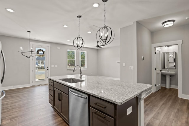 kitchen with sink, an island with sink, stainless steel dishwasher, dark brown cabinets, and light stone countertops