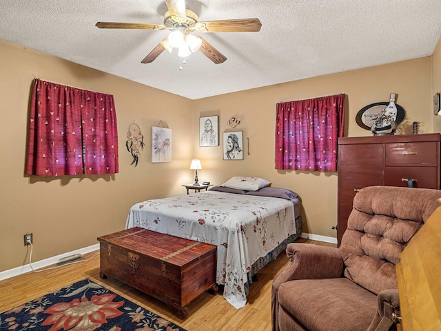 bedroom featuring a textured ceiling, ceiling fan, and light hardwood / wood-style floors